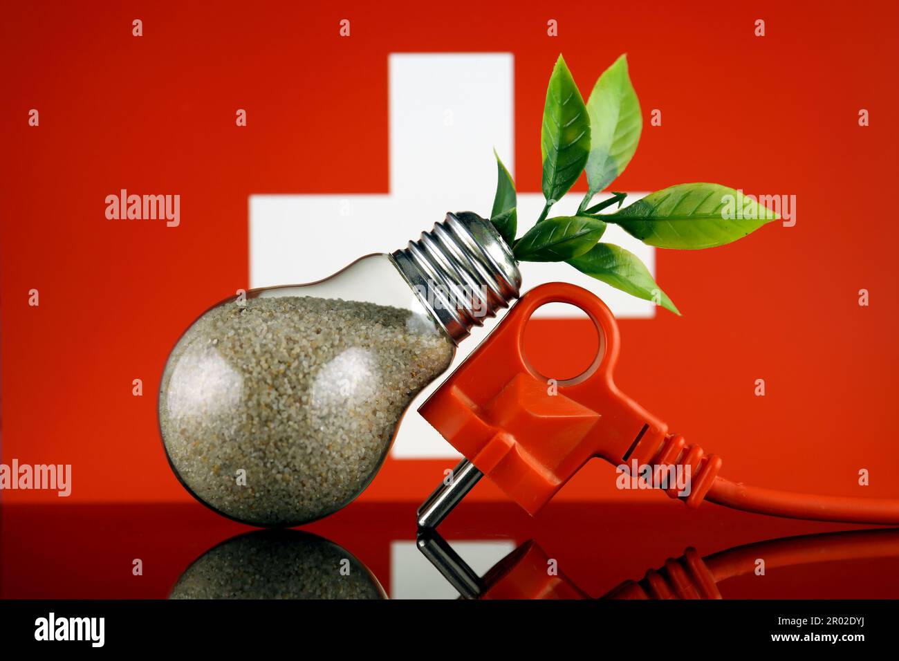 Stöpsel, Pflanze wächst in der Glühbirne und Schweizer Flagge. Konzept für umweltfreundliche erneuerbare Energien. Stockfoto