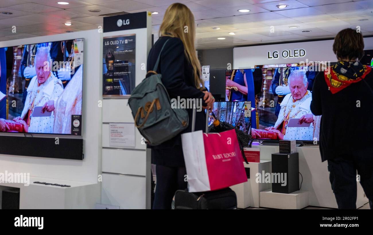 London, Großbritannien. 6. Mai 2023 Die Menschen sehen die Krönung von König Karl III. Und Königin Camilla auf Großbildfernsehern im Flaggschiff John Lewis Kaufhaus in der Oxford Street. Dies ist die erste Krönung des Vereinigten Königreichs seit 70 Jahren und die erste im digitalen Zeitalter. Kredit: Stephen Chung / Alamy Live News Stockfoto