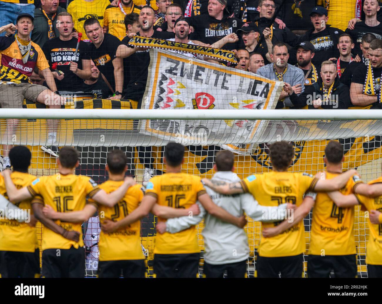 Dresden, Deutschland. 06. Mai 2023. Fußball: 3. Liga, SG Dynamo Dresden - SV Wehen Wiesbaden, Spieltag 35, Rudolf-Harbig-Stadion. Dynamos Fans im K-Block zeigen ein Banner „Zweite Liga wir kommen“, während das Team nach dem Sieg jubelt. Kredit: Robert Michael/dpa/ZB/dpa/Alamy Live News Stockfoto