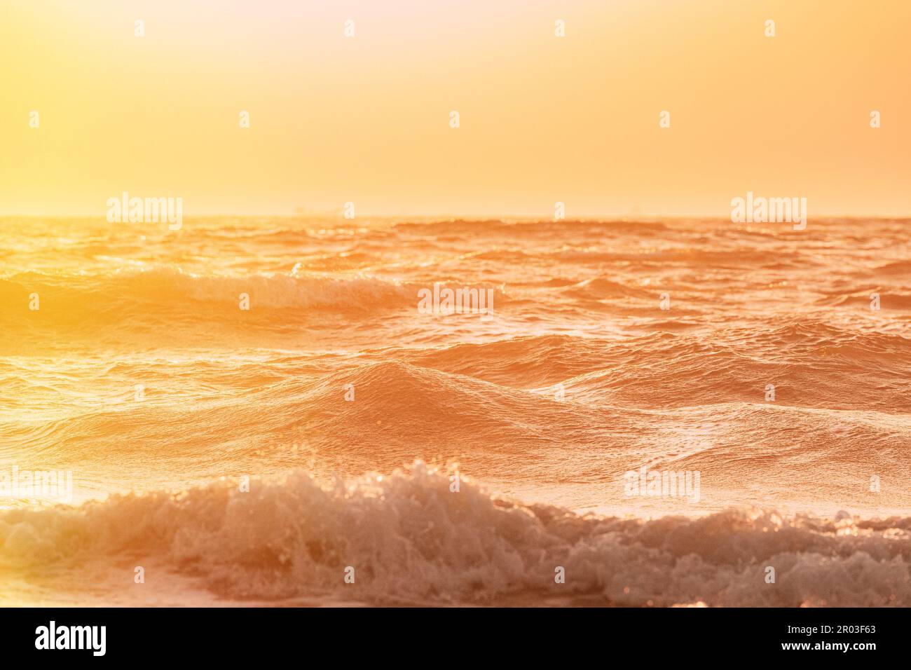 Abenduntergang über dem Meer. Riplpe Meerwasseroberfläche mit kleinen Wellen. Wasserschaum spritzt. Wunderschöne Natur mit Meereslandschaft Stockfoto