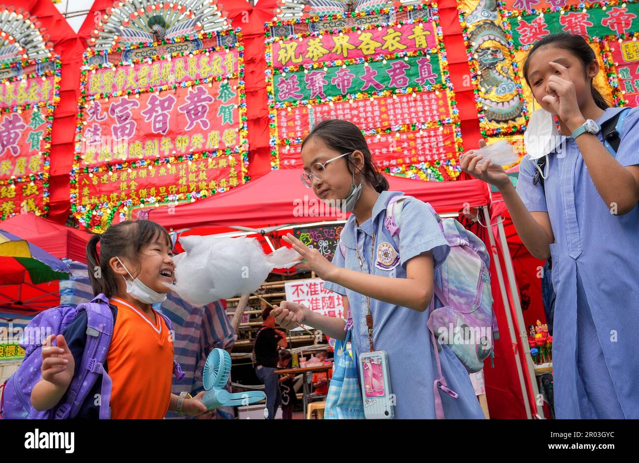 Das Tsing Yi Bamboo Theatre findet vom 1. Bis 5. Mai auf dem Fußballfeld der Tsing Yi Athletic Association statt, um den Geburtstag der Gottheit von Chun Wan zu feiern. Das Bild zeigt ein Kind, das auf dem festlichen Markt Zuckerwatte isst. 02MAY23 SCMP/Elson Li Stockfoto