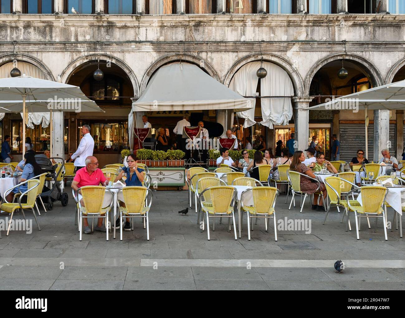 Das Caffè Lavena ist ein historisches Kaffeehaus, das 1750 auf dem berühmten Markusplatz errichtet wurde und im Sommer mit Touristen in Venedig, Venetien, Italien, unterwegs ist Stockfoto