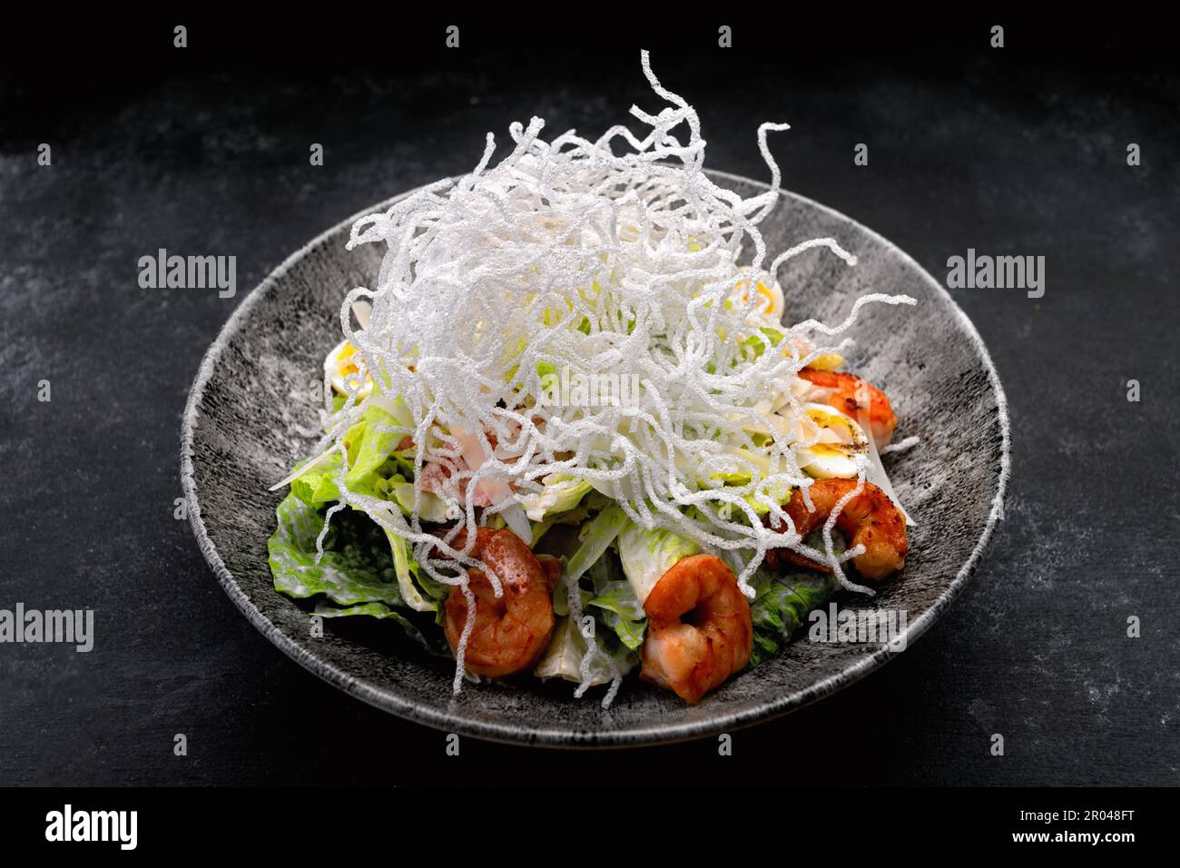 Caesar Salat mit gegrillten Garnelen und knusprigen Reisstäbchen Stockfoto