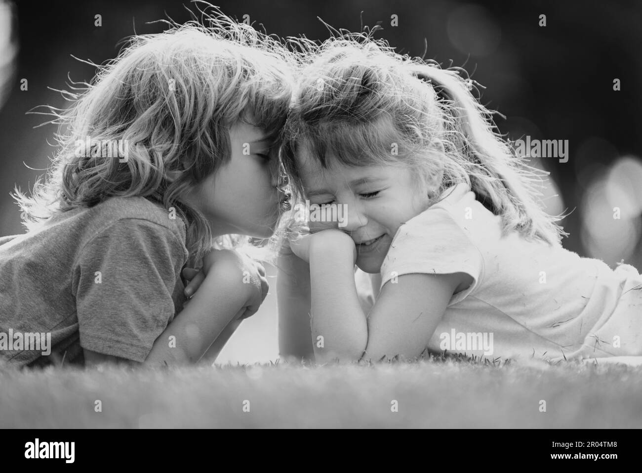 Kind Junge und Mädchen umarmen sich mit Liebe im Frühlingsgarten. Zwei kleine Kinder umarmen sich im Park. Kinder Freunde spielen zusammen im Freien Stockfoto