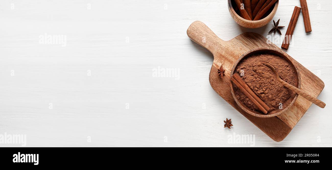 Schüssel mit Zimtpulver und Stäbchen auf weißem Holzhintergrund mit Platz für Text, Draufsicht Stockfoto