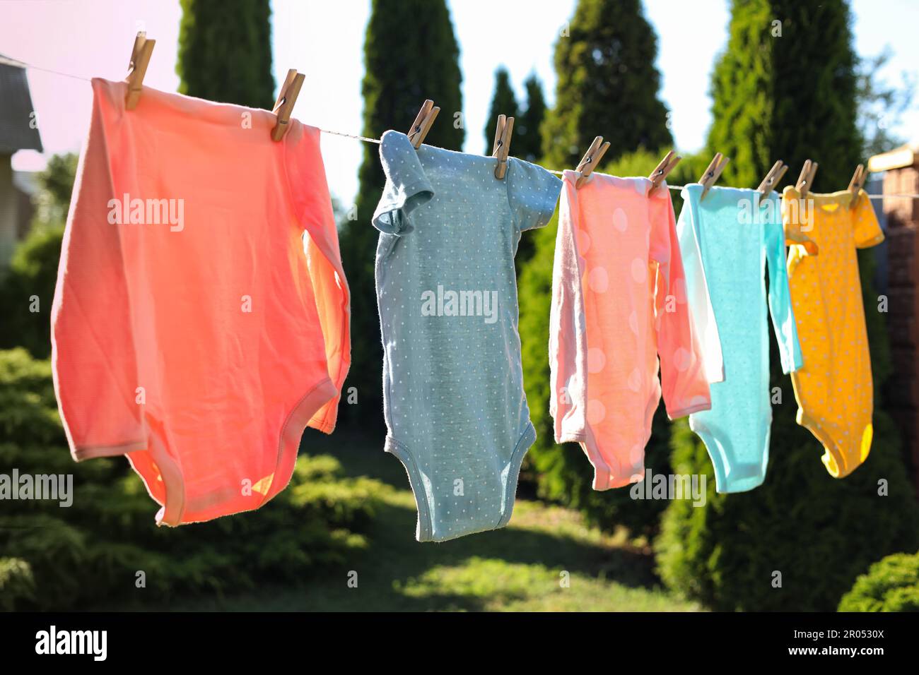 Babykleidung trocknet an der Wäscheleine im Freien Stockfoto