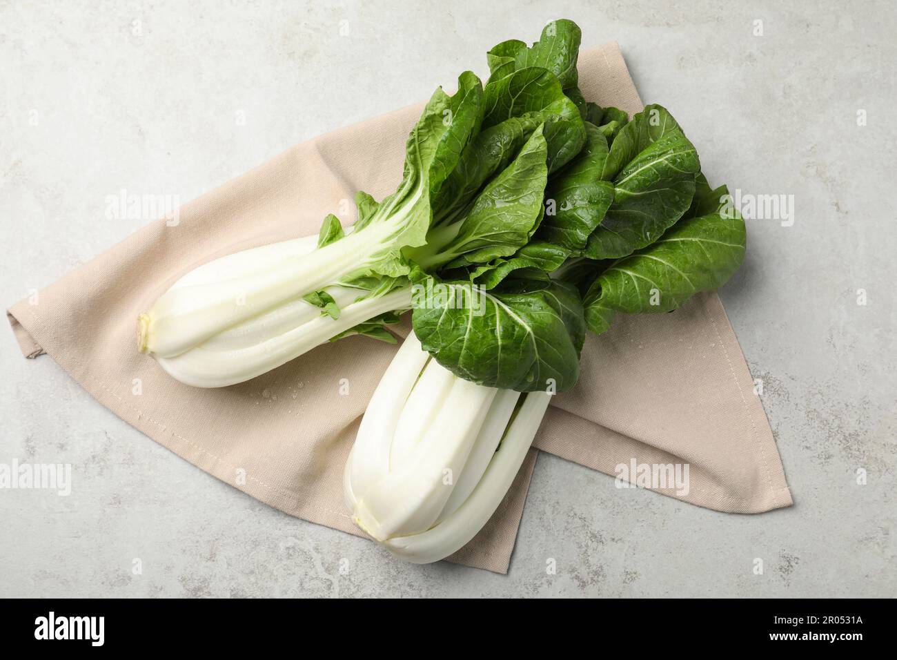 Frischer grüner pak Choy Kohl mit Wassertropfen auf hellgrauem Tisch, flach liegend Stockfoto