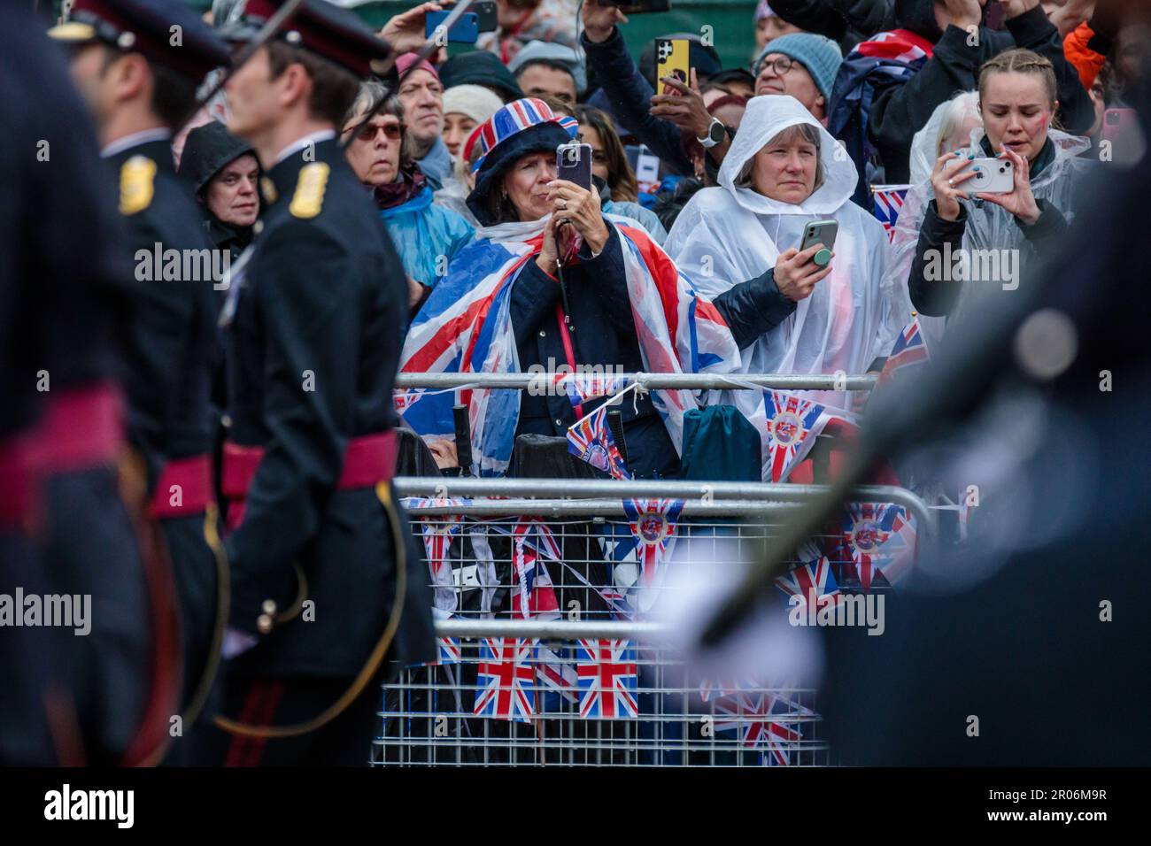 The Mall, London, Großbritannien. 6. Mai 2023 Königliche Fans im Regen auf der Mall während der Prozession zur Krönung von König Karl III. Halten die Action auf ihren Mobiltelefonen fest. Foto: Amanda Rose/Alamy Live News Stockfoto