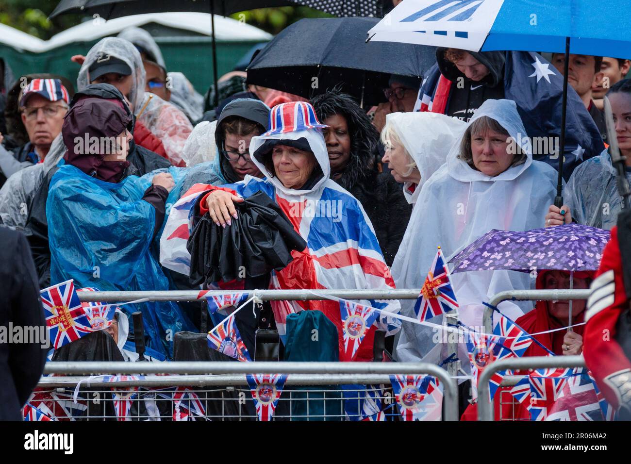 The Mall, London, Großbritannien. 6. Mai 2023 Während der Prozession zur Krönung von König Karl III. Öffnet ein königlicher Fan einen Schirm auf der Mall Foto: Amanda Rose/Alamy Live News Stockfoto