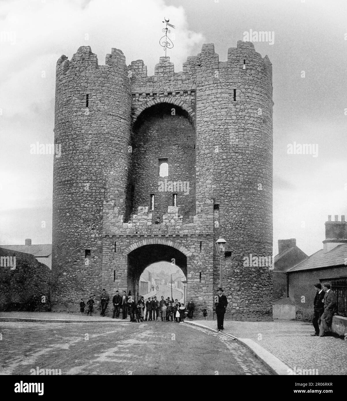 Ein Blick aus dem späten 19. Jahrhundert auf das Saint Laurence Gate, erbaut im 13. Jahrhundert als Teil der Festungen der mittelalterlichen Stadt Drogheda in der Grafschaft Louth, Irland. Es ist ein barbikaner oder verteidigtes Vorderwerk, das direkt vor dem ursprünglichen Tor stand, von dem keine Oberflächenspuren überlebt haben. Das Gebäude besteht aus zwei Türmen, jedes mit vier Etagen, verbunden durch eine Brücke oben, ein Eingangsbogen auf Straßenebene, unter dem ein Schlitz liegt, von dem aus ein Portcullis ursprünglich angehoben und abgesenkt werden konnte. Stockfoto