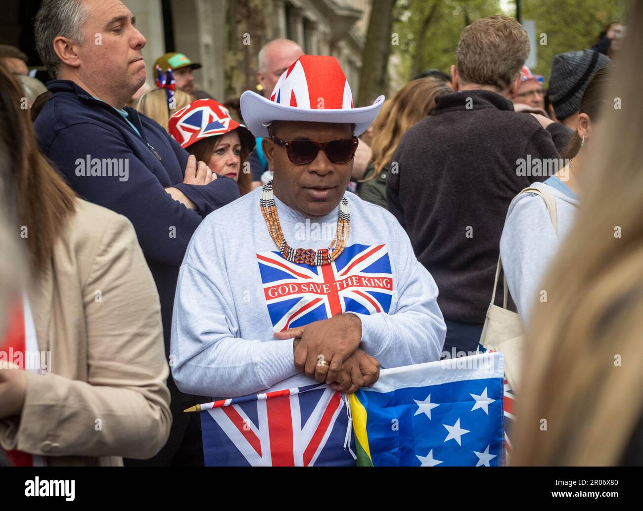 In einem Meer von Menschen, die die Krönung von König Karl III. In London, Großbritannien, feiern, sticht ein schwarzer Mann mittleren Alters mit seiner Union Jack-Mütze und seinen grauen s hervor Stockfoto