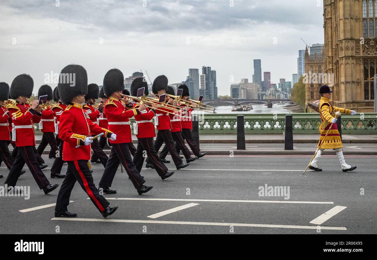 Während sie in vollen Zeremonialkostümen über die Westminster Bridge marschieren, spielt eine Band der Bristish Army Guards Division Musik, die von einer Band l geleitet wird Stockfoto