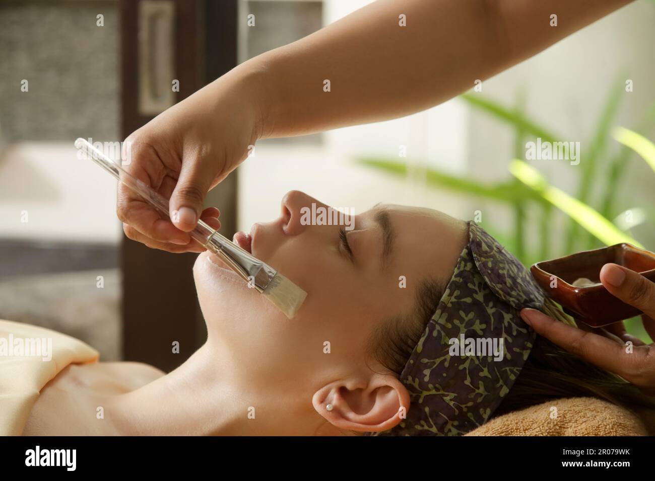 Junge Frau im natürlichen Schönheitsbad, die eine Gesichtsbehandlung bekommt. Relaxation, Entgiftung, Exfoliation des Hautrejuvenationskonzepts. Stockfoto