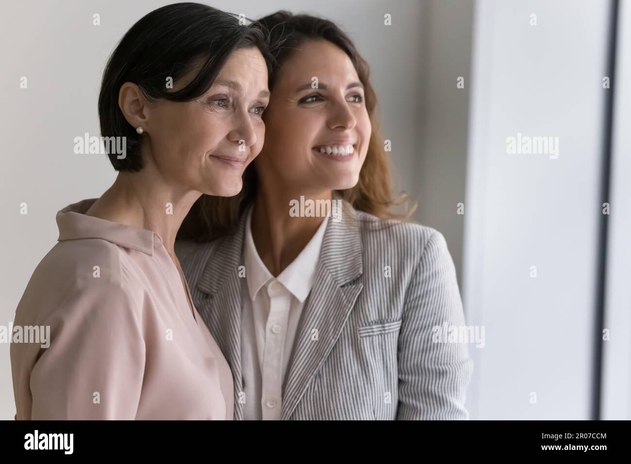 Frauen mittleren Alters und junge Frauen, die tagträumen und aus dem Fenster starren Stockfoto