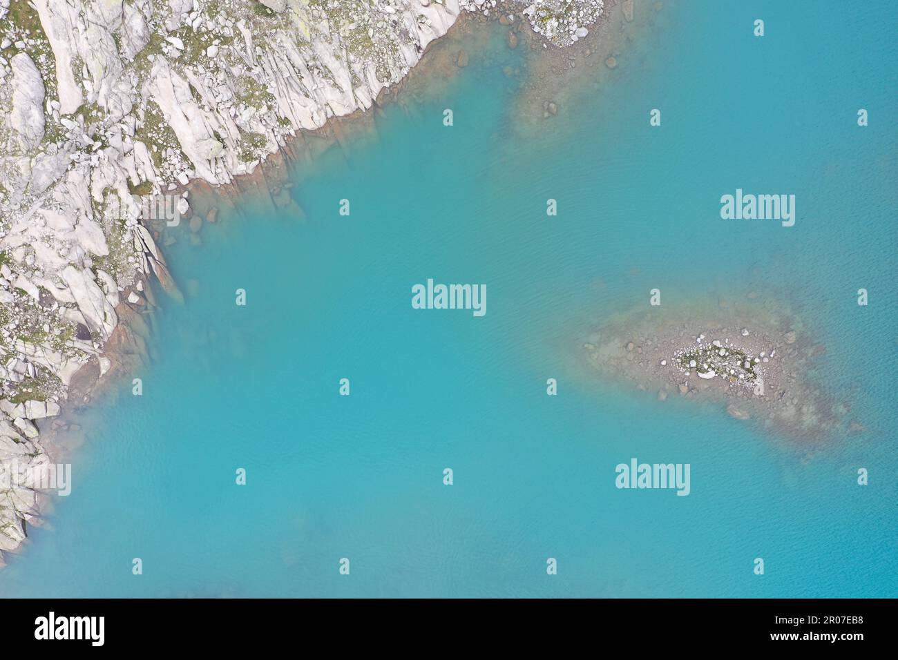 Fragmente aus der Luft des Lago Vedretta, Val Nambrone – türkisfarbenes Gletscherwasser und alpines Gesteinsgestein Stockfoto