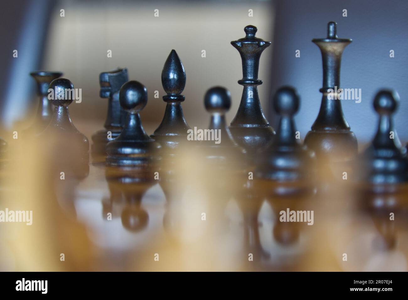 Eine Nahaufnahme von schwarzen Schachfiguren gegen die weißen auf einem Brett Stockfoto