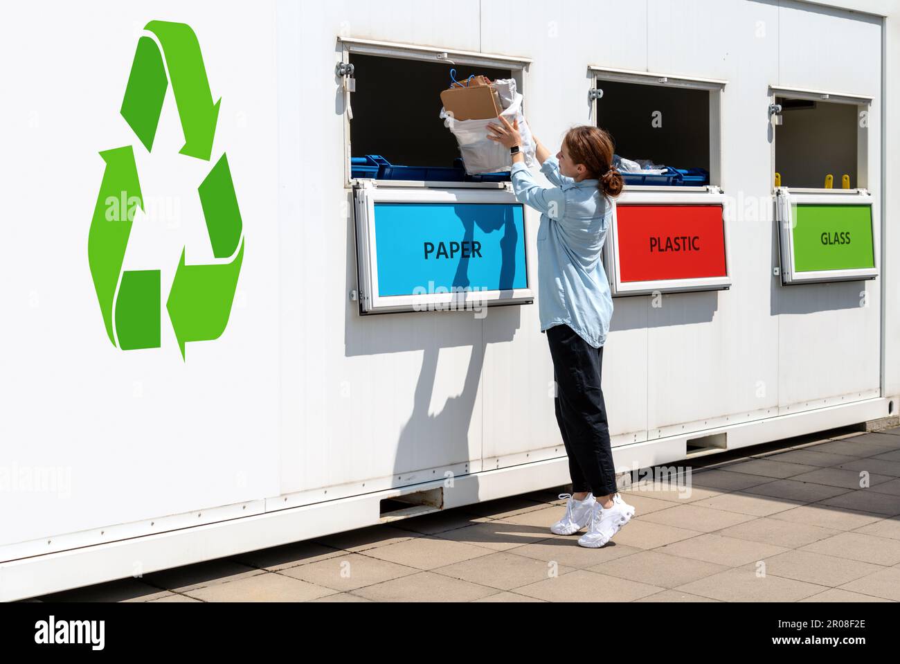 Getrennte Müllsammelstation auf der Straße und eine Frau, die Papier in den Müll wirft. Stockfoto