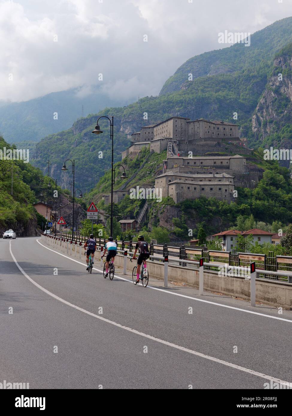 Radfahrer passieren Fort of Bard (Forte di Bard) im Aosta Valley, NW Italien Stockfoto