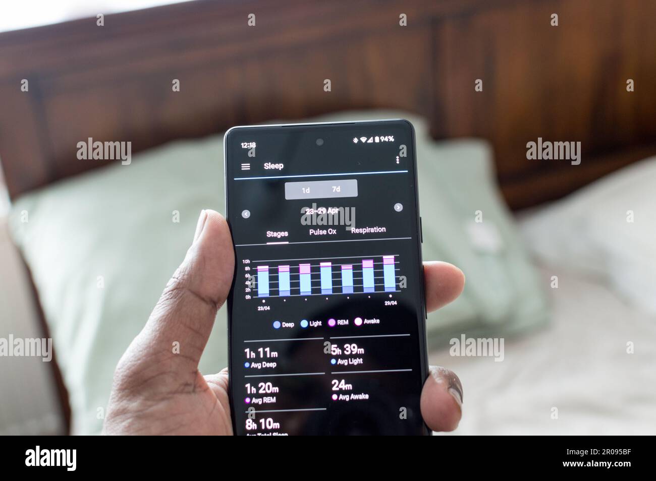 Männlicher Erwachsener, der das Schlaf-Tracker-Muster für die Woche überprüft Stockfoto
