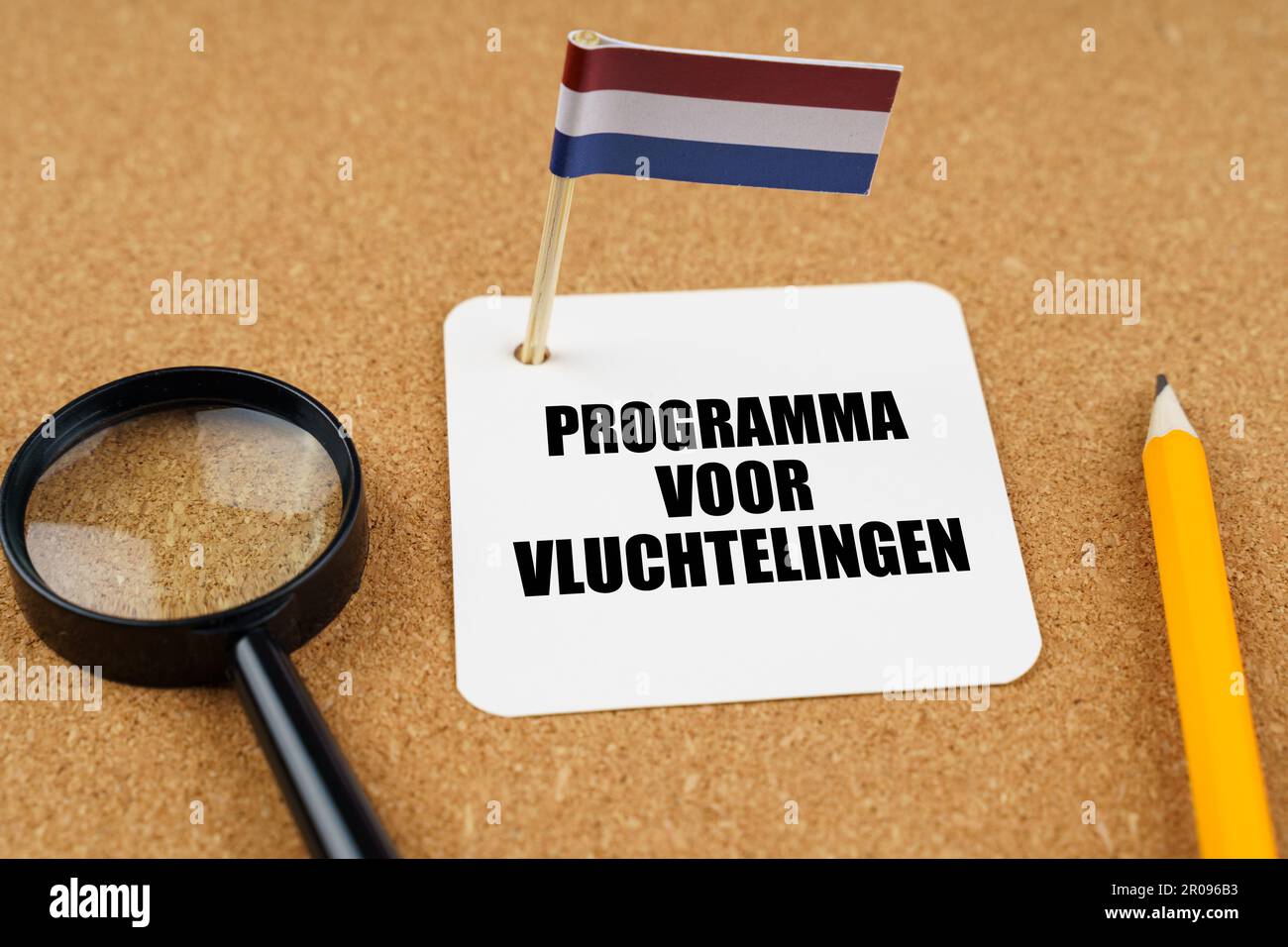 Auf dem Tisch liegt die Flagge der Niederlande, ein Bleistift, eine Lupe und ein Blatt Papier mit einer Inschrift auf Niederländisch, die ins Englische übersetzt wird Stockfoto