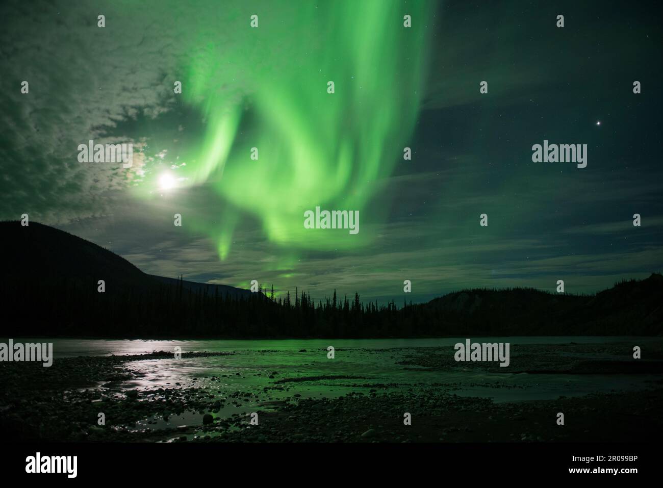 Nordlichter über dem Nahanni River, Northwest Territories, Kanada. Aurora borealis reflektiert das fließende Wasser bei Vollmond. Stockfoto