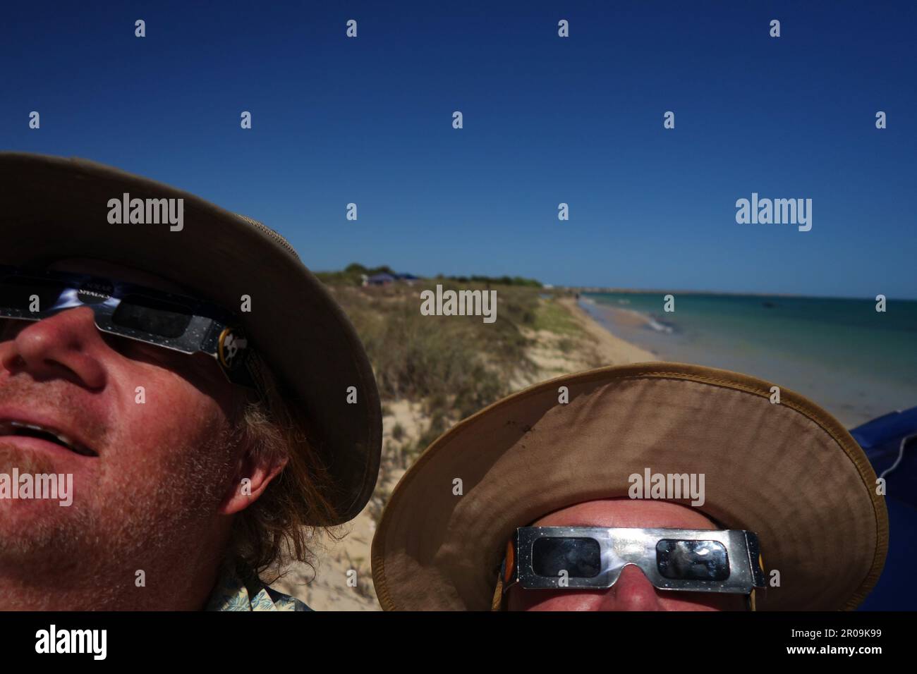 Menschen, die die Sonnenfinsternis am Strand von North Lefroy Bay, Ningaloo National Park, Westaustralien, 20. April 2023 beobachten. Kein MR oder PR Stockfoto