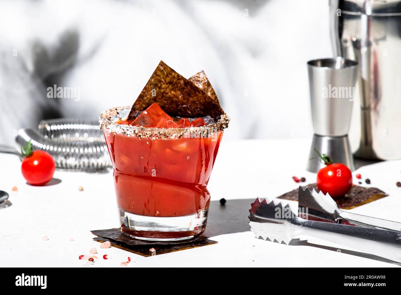 Miso Bloody mary alkoholisches Cocktailgetränk mit Tomatensaft, japanischen Gewürzen, Wodka und Nori. Weißer Hintergrund, hartes Licht, Stahlstangen-Werkzeuge Stockfoto