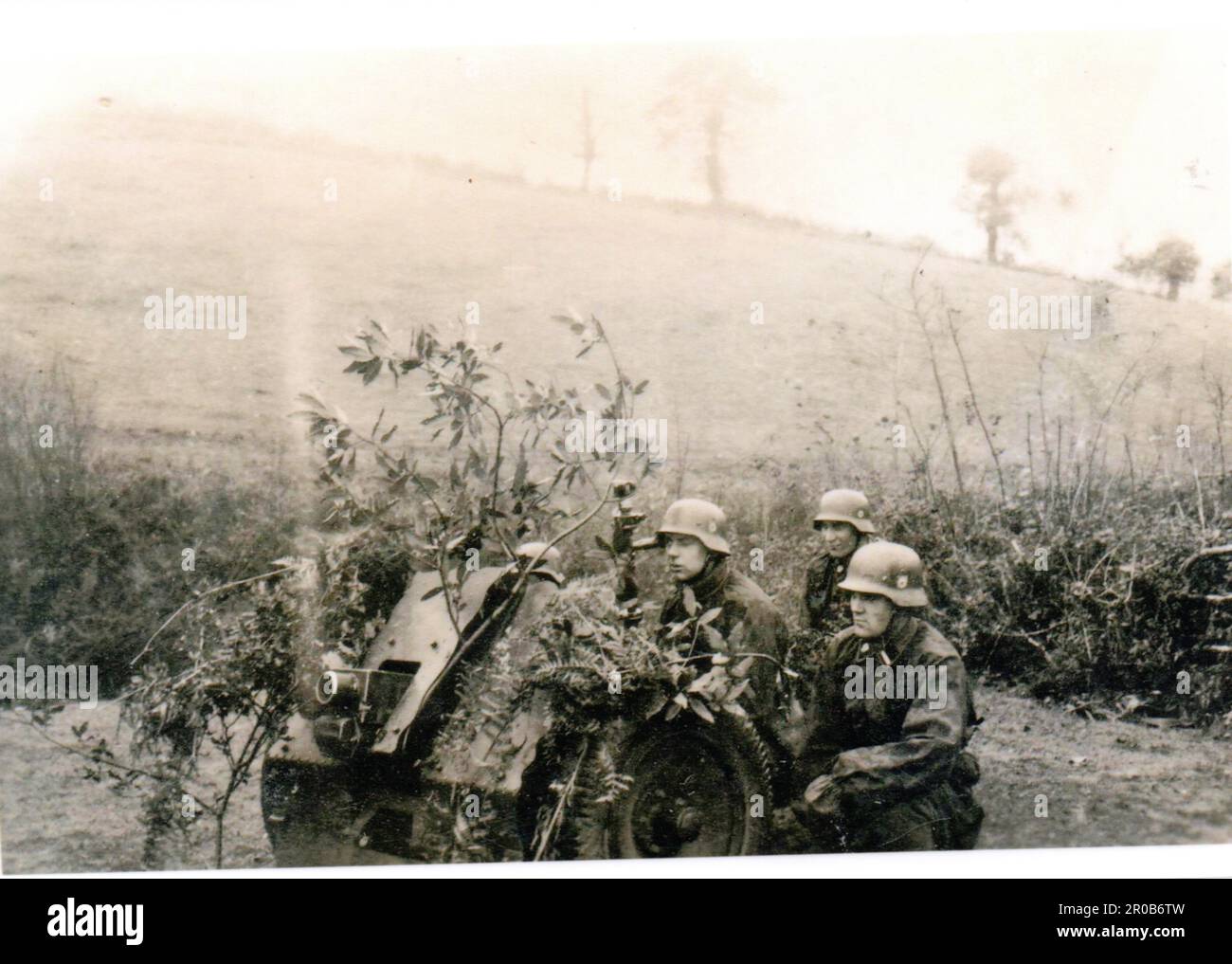 2. Weltkrieg Schwarzweißfoto Deutsche Soldaten trainieren auf einem 75mm Infanteriegewehr . Die Männer sind von der 3. SS Totenkopf Division. Sie sind in Camo Smocks gekleidet Stockfoto