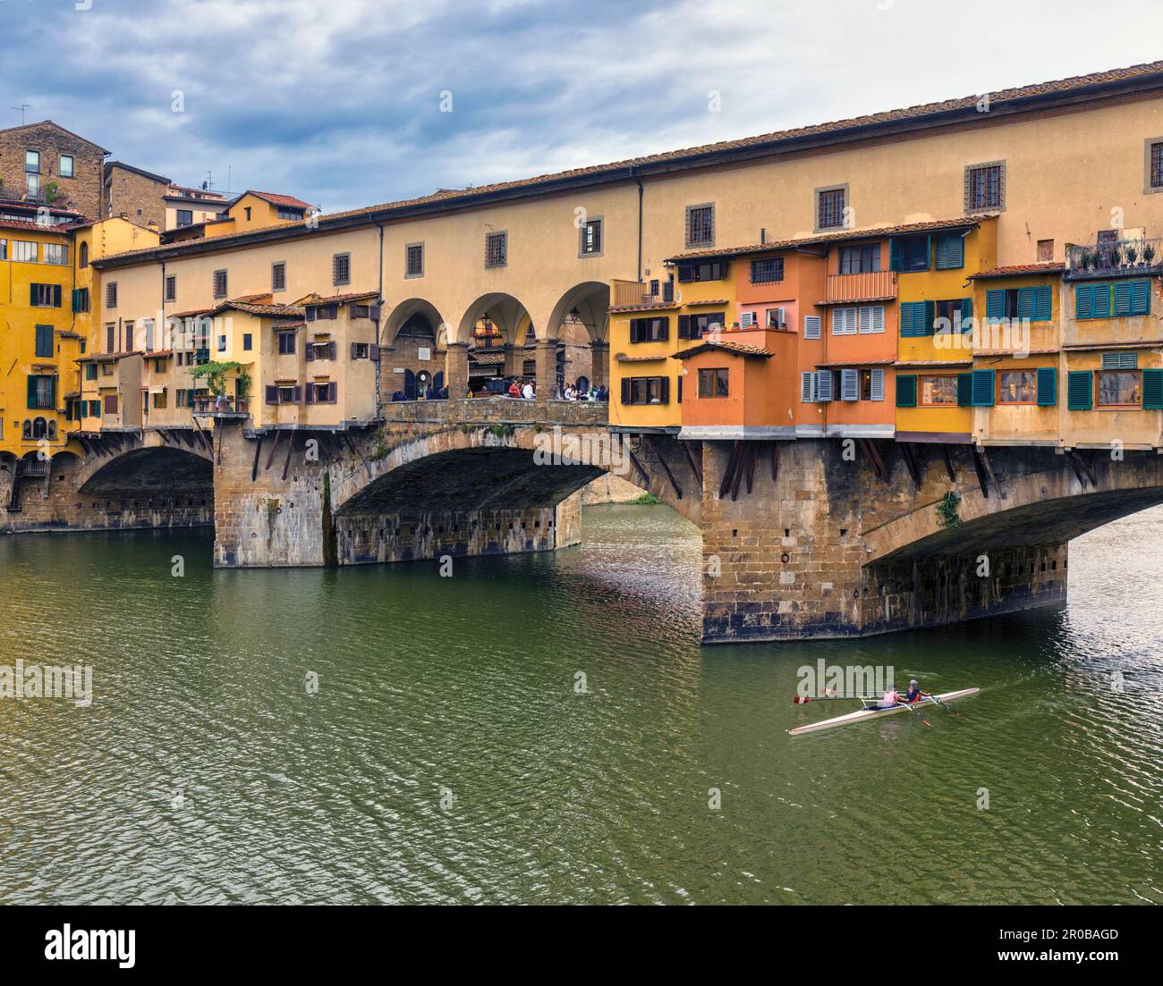Die Ponte Vecchio, die alte Brücke, am Fluss Arno und die Doppel-Scullers. Florenz, Toskana, Italien. Das historische Zentrum von Florenz gehört zum UNESCO-Weltkulturerbe Stockfoto