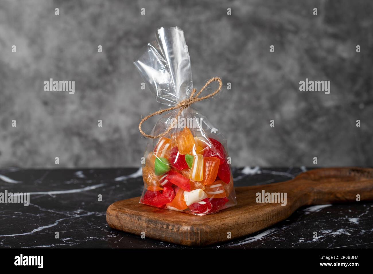 Obsttropfen. Abgepackte Süßigkeiten mit Fruchtgeschmack auf dunklem Hintergrund Stockfoto