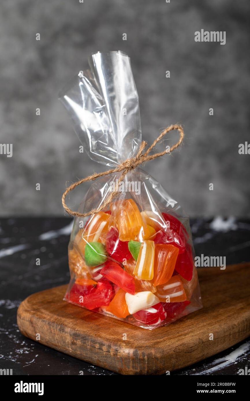 Obsttropfen. Abgepackte Süßigkeiten mit Fruchtgeschmack auf dunklem Hintergrund. Schließen Stockfoto