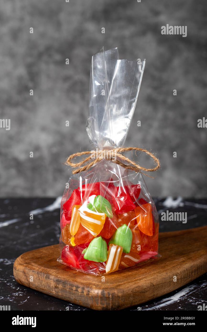 Obsttropfen. Abgepackte Süßigkeiten mit Fruchtgeschmack auf dunklem Hintergrund Stockfoto