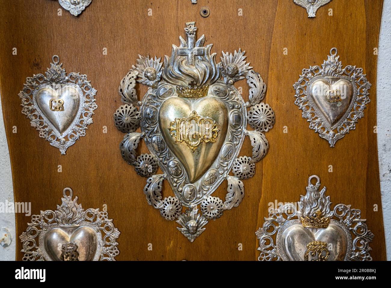 Ex-voto in Hingabe für die Gnaden der Heiligen Dreifaltigkeit von Vallepietra. Fotos und Herzen in Silber. Vallepietra, Latium Stockfoto