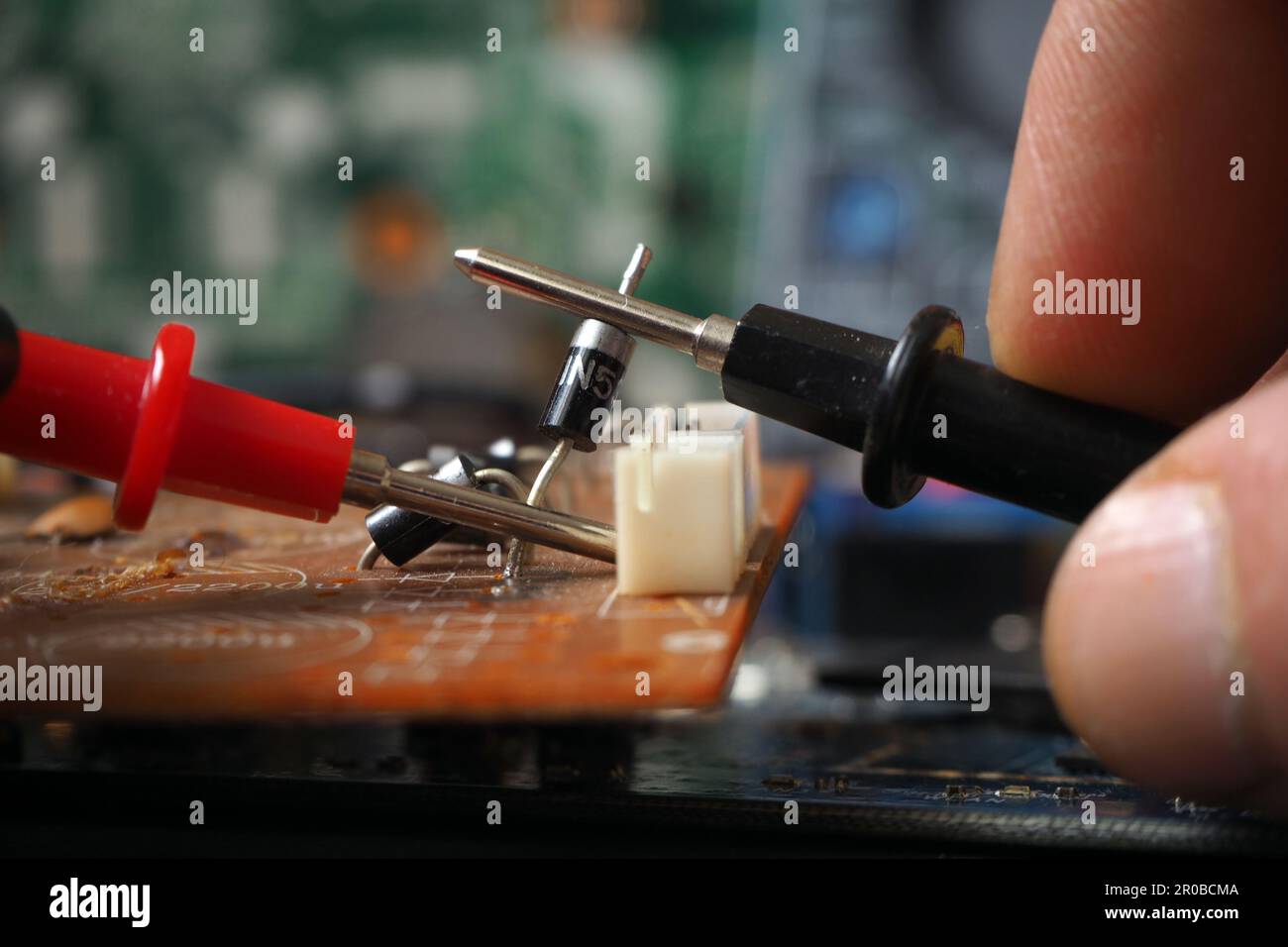 Elektrotechniker prüft elektronische Bauteile auf der Leiterplatte. Auf Diode fokussiert. Stockfoto