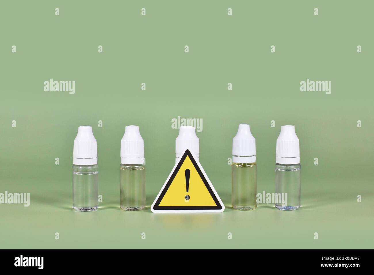 Flaschen mit flüssigen Lösungen für elektronische Zigaretten mit Warnschild Stockfoto