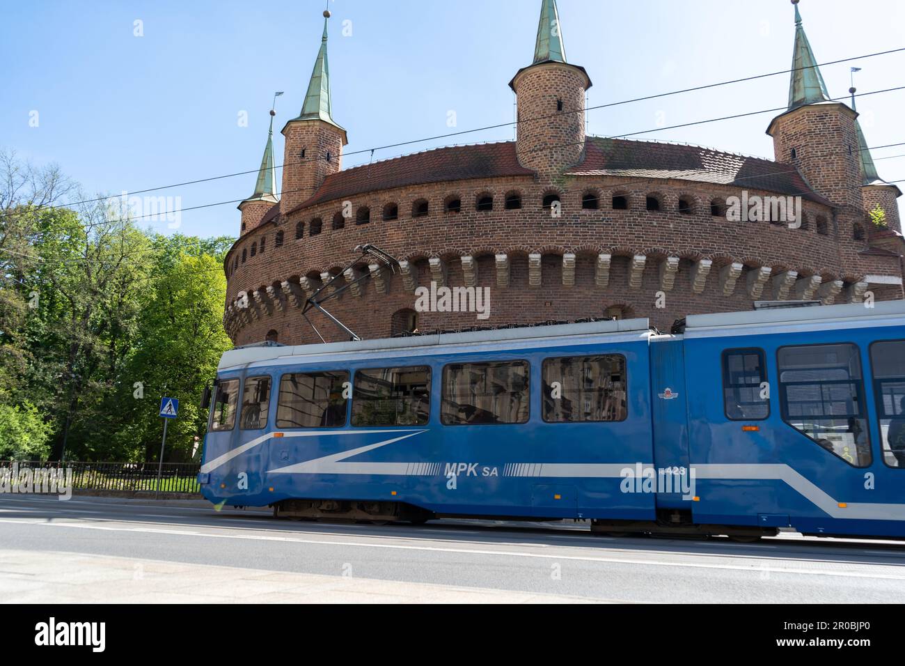 EU8N Straßenbahn neben dem Kraków Barbican, Barbakan Krakowski-Denkmal. Straßenbahn MPK Krakau Öffentliche Verkehrsmittel auf der Basztowa Straße in Krakau, Polen. Stockfoto