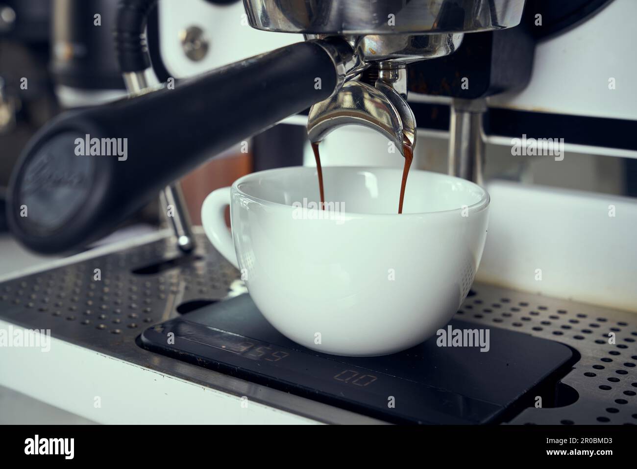 Eine Espressomaschine gießt Espresso in eine Kaffeetasse. Stockfoto