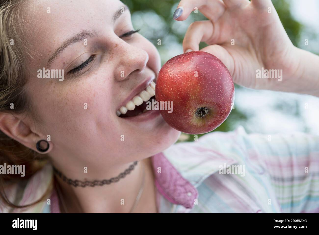Nahaufnahme einer jungen Frau mit rotem Apfel, Bayern, Deutschland Stockfoto