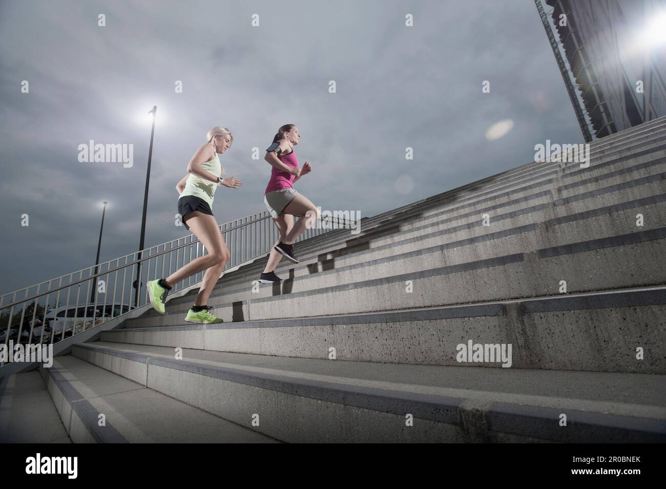 Zwei Frauen joggen im Morgengrauen auf den Treppen, Bayern, Deutschland Stockfoto