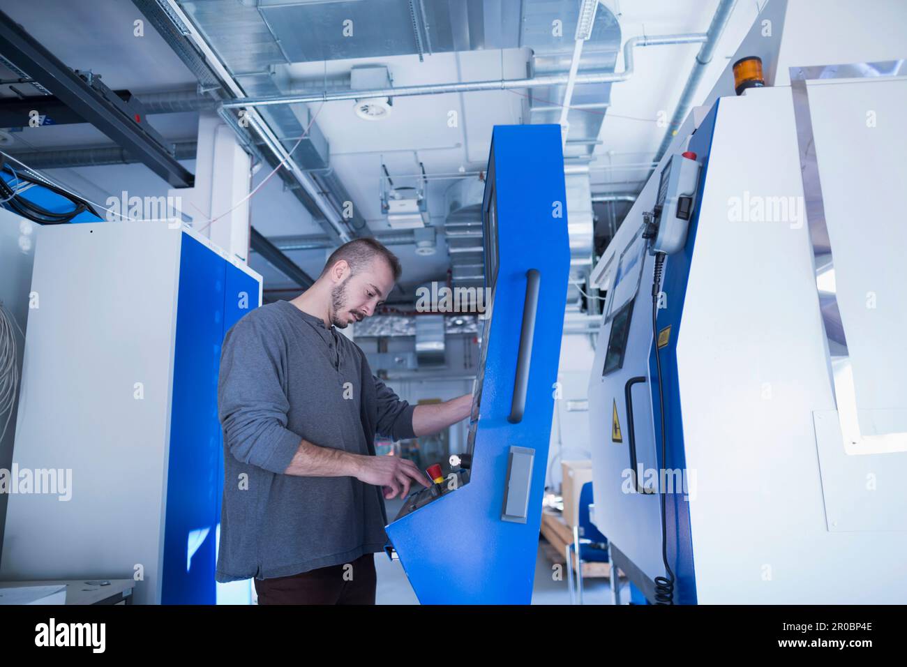 Junger männlicher Ingenieur, der eine Schaltanlage in der Schalttafel in Freiburg im Breisgau, Baden-WÃ¼rttemberg, Deutschland, kontrolliert Stockfoto