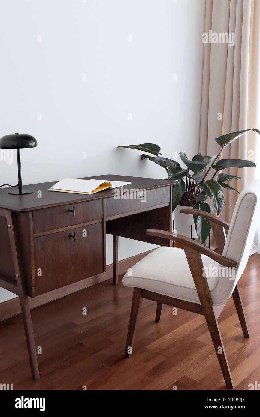 Arbeitsbereich mit Vintage-Schreibtisch und Stuhl und Philodendron dahinter Stockfoto