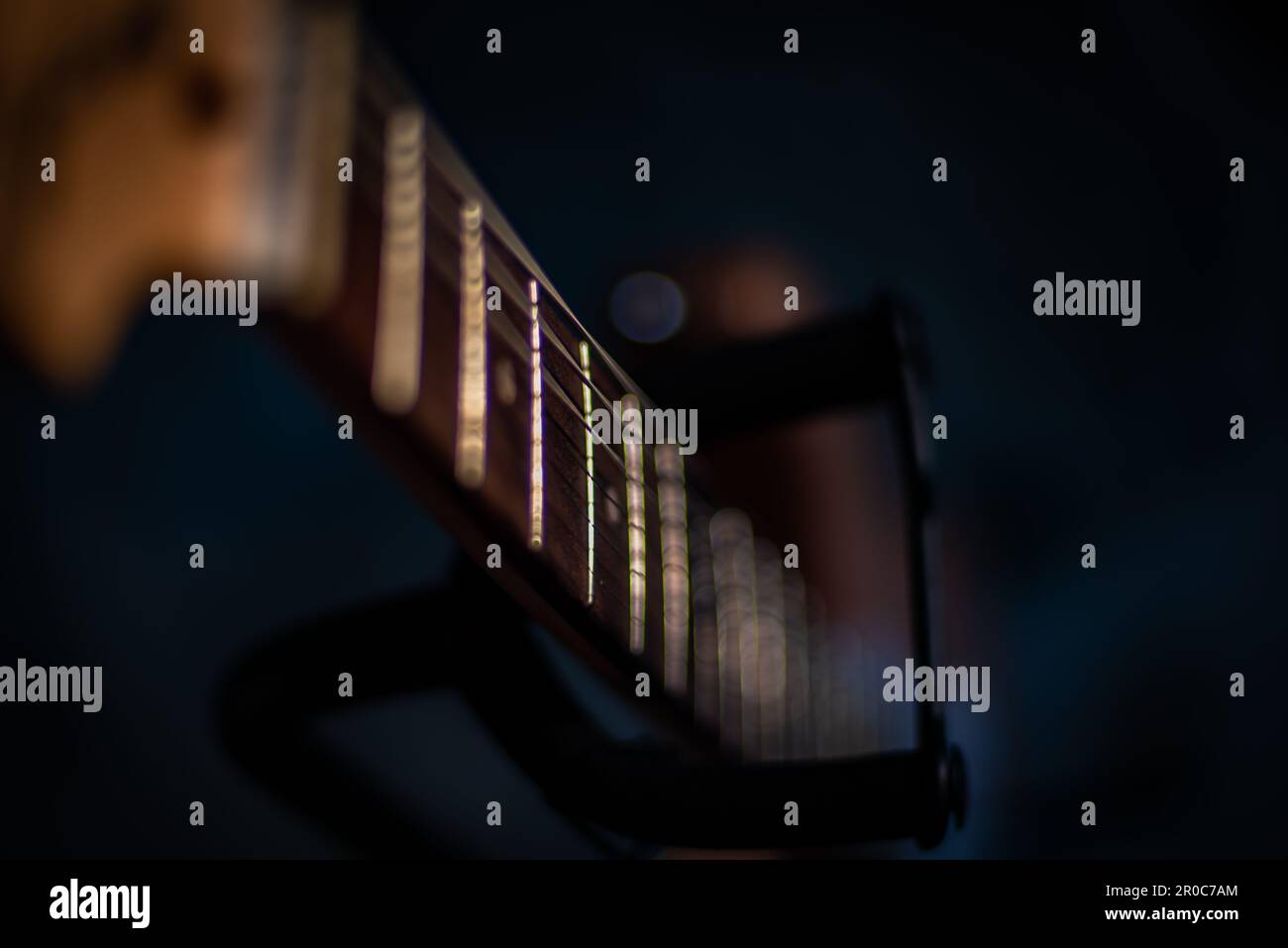 Nahaufnahme des Nackens der elektrischen Gitarre bis zum unteren Rand im Gitarrenständer Stockfoto