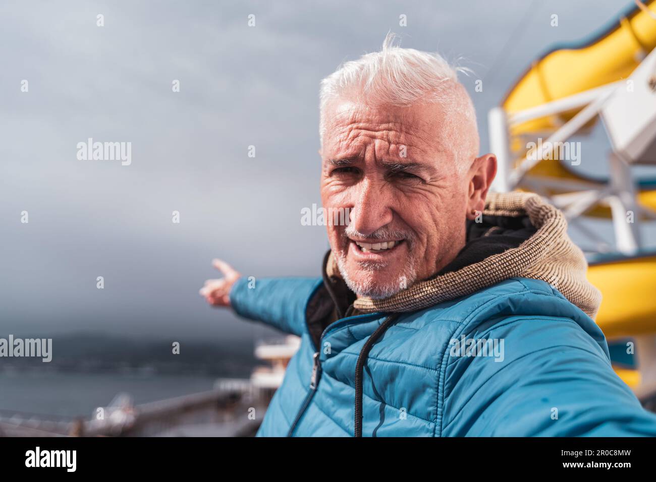 Gutaussehender Mann mittleren Alters, der ein Selfie auf dem Deck eines Schiffes macht - glücklicher Tourist, der mit dem Kreuzfahrtschiff reist - Tourismus- und Urlaubskonzept Stockfoto