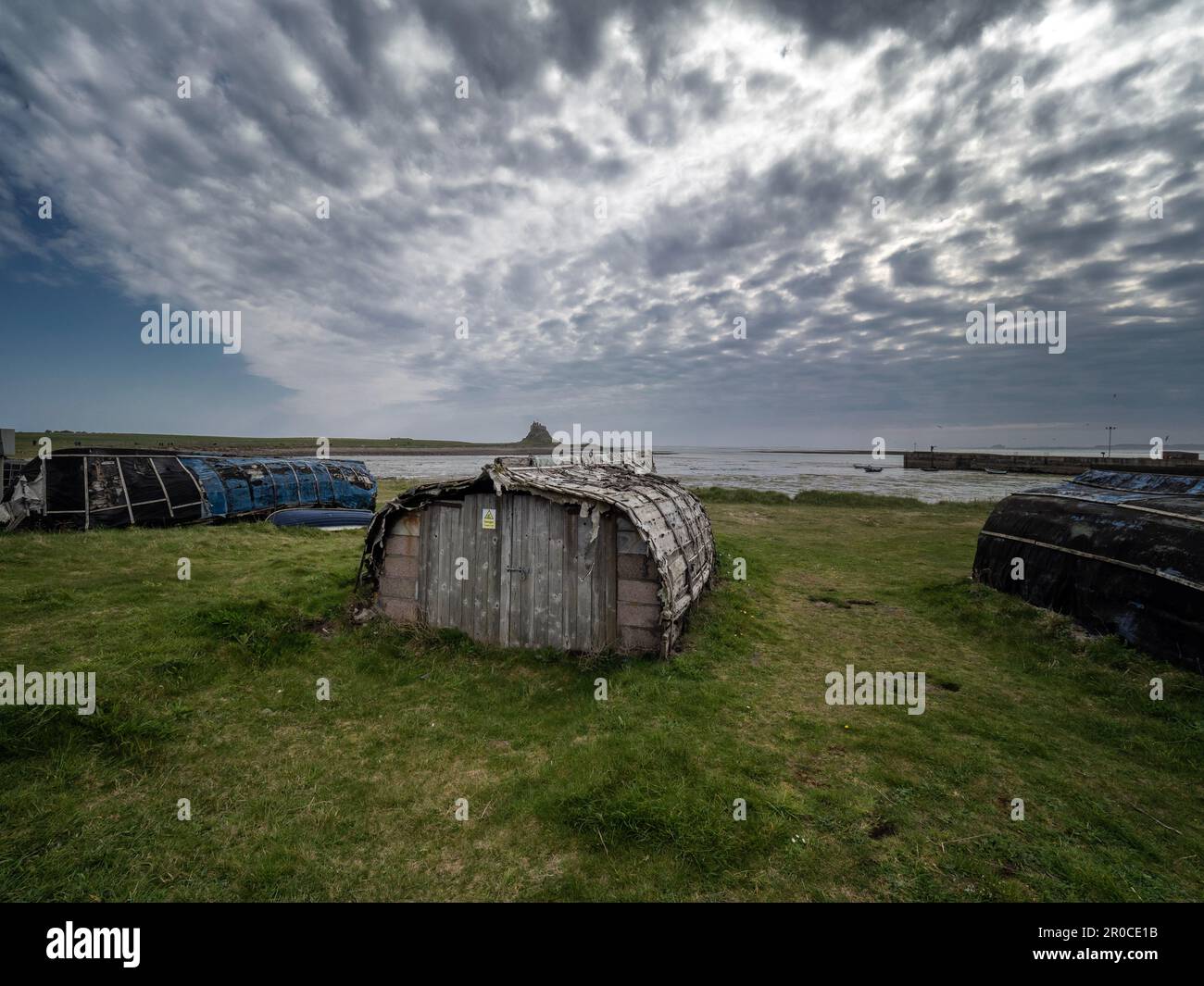 Boote, die als Ladenhäuser am Strand auf der Heiligen Insel Lindisfarne, Northumberland, England, Großbritannien, genutzt wurden Stockfoto