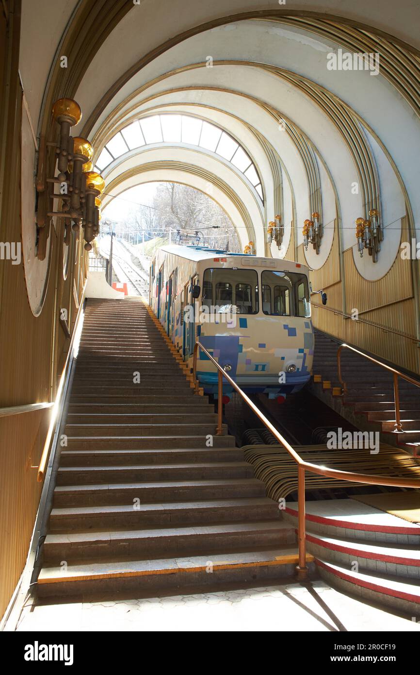 Eine blau-weiße Seilbahn steigt auf Schienen entlang der Steigung. Seilbahn, Seitenansicht. Station Kiew, Ukraine Stockfoto