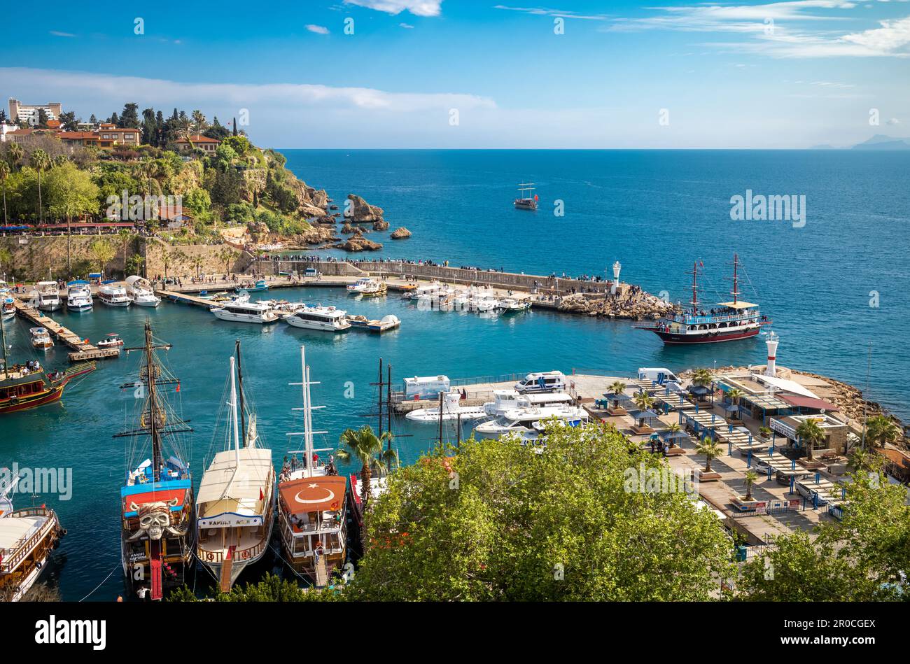 Ein Touristenboot fährt an einem sonnigen Tag anmutig durch den Eingang des alten Hafens in Kaleici, der bezaubernden Altstadt in Antalya, Türkei. Die Stockfoto