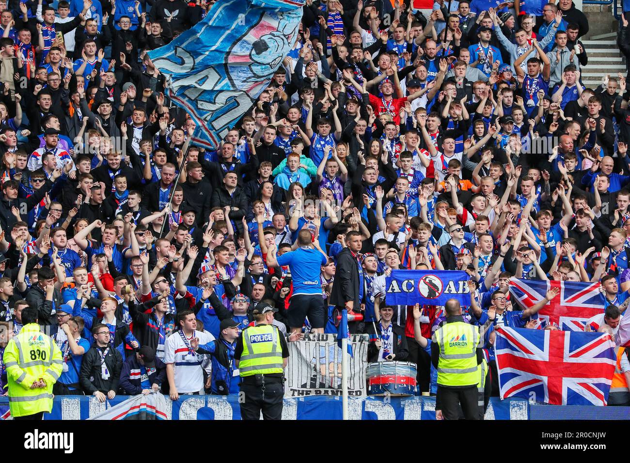 Glasgow, Großbritannien. 07. Mai 2023. Vor dem Beginn des schottischen Premiership-Spiels zwischen Rangers und Aberdeen schlossen sich in Ibrox, der Heimat der Rangers, der Rangers und Aberdeen Teams zusammen mit Fans zusammen, um die Nationalhymne zu Ehren der Krönung von König Charles am 6. Mai 2023 zu singen Credit: Findlay/Alamy Live News Stockfoto