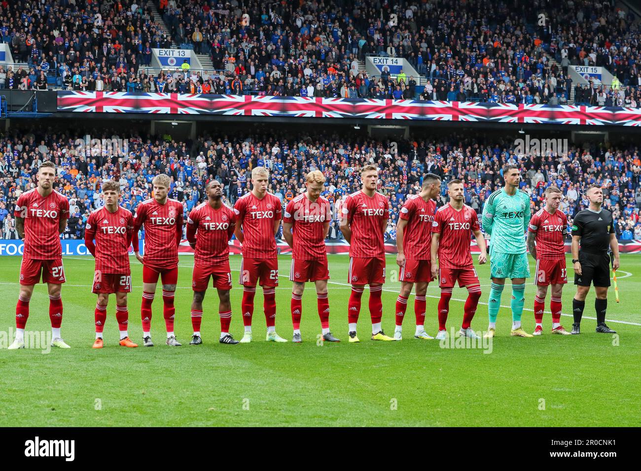 Glasgow, Großbritannien. 07. Mai 2023. Vor dem Beginn des schottischen Premiership-Spiels zwischen Rangers und Aberdeen schlossen sich in Ibrox, der Heimat der Rangers, der Rangers und Aberdeen Teams zusammen mit Fans zusammen, um die Nationalhymne zu Ehren der Krönung von König Charles am 6. Mai 2023 zu singen Credit: Findlay/Alamy Live News Stockfoto