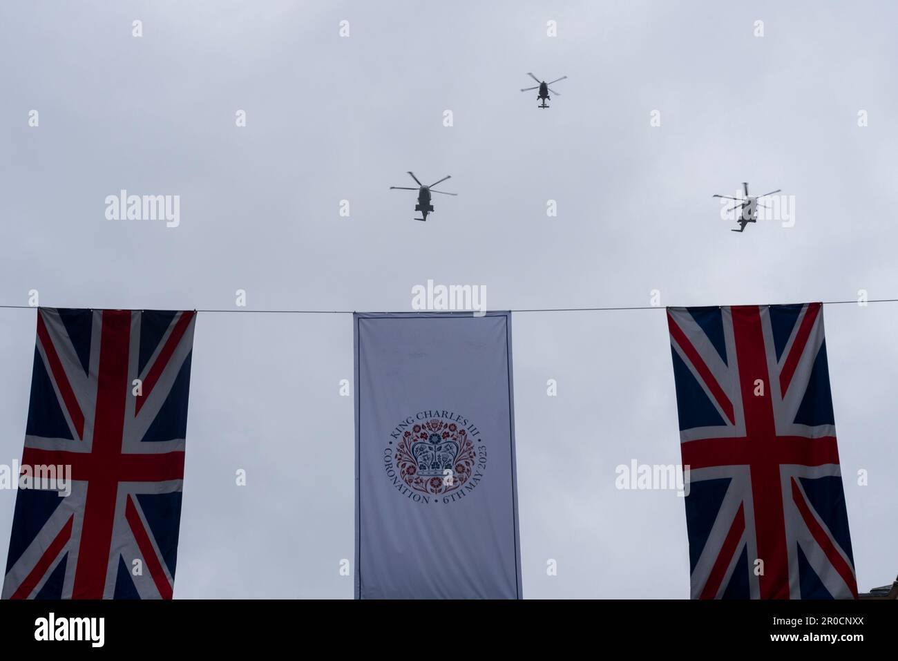 Royal Navy Hubschrauber fliegen über Krönung und Union Jack Flaggen nach der Krönung von König Karl III Westland Wildcat und zwei Merlin Hubschrauber Stockfoto
