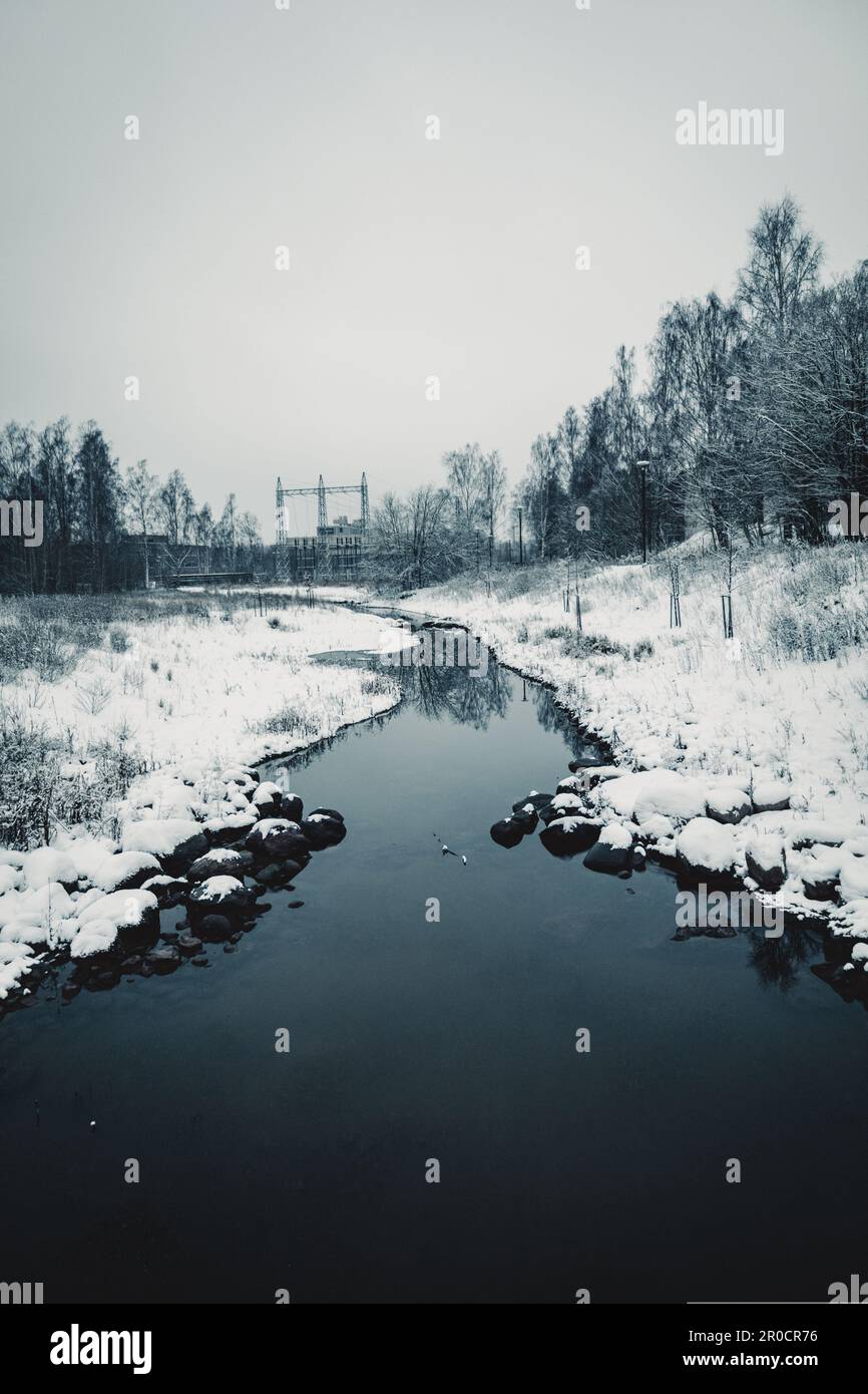 Eine malerische Winterszene mit einem gewundenen Bergbach und unberührtem weißen Schnee in der umliegenden Landschaft Stockfoto